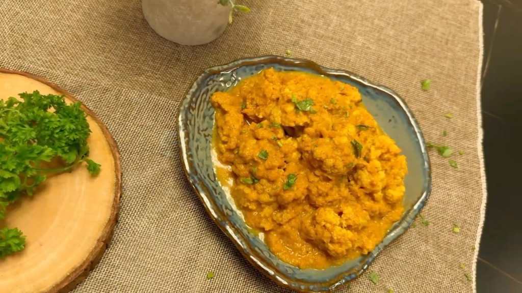 GOBI DUM ON A SERVING BOWL WITH A FRESH PARSLEY ON THE SIDE